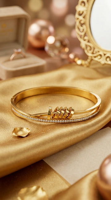 Gold Stainless Steel Bangle With A Twist And Rings (BA032)
